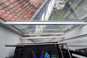 Glasreinigung eines Aufzugsschachtes durch Industriekletterer in Wien