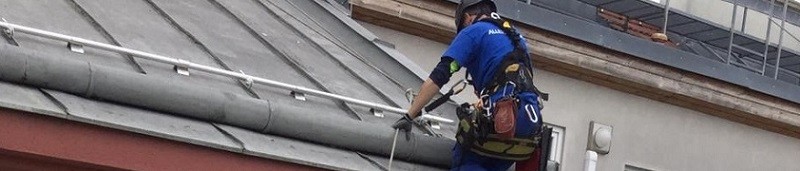 Professioneller Industriekletterer beim seilklettern an einem Wohnhaus in Wien als Beispielbild für Fassadenklettern zur Gebäudereinigung